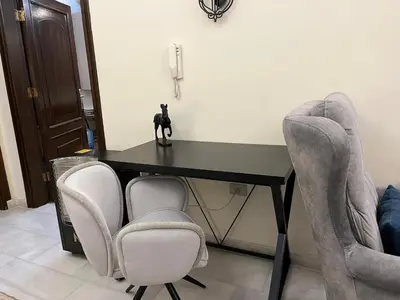 a black table with chairs and a black cat on it at Behind Mecca Mall in Amman