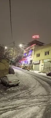a car parked on a snow covered street at night at Al Midan Hotel in Amman
