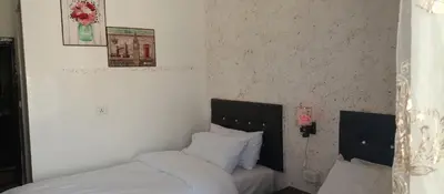 a bedroom with a bed with white sheets and pillows at Al Midan Hotel in Amman