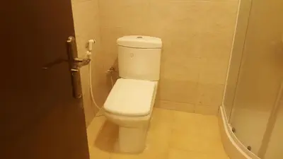 a bathroom with a white toilet in a stall at Sultan Home in Wadi Musa