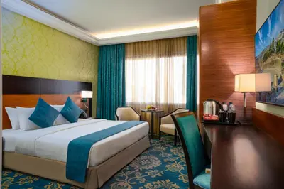 a hotel room with a bed and a table at Corp Amman Hotel in Amman