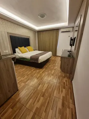 a bedroom with a bed with yellow pillows on it at Shweiki International Hotel in Aqaba