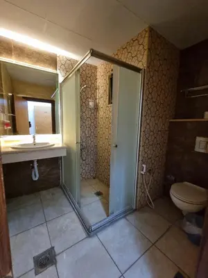 a bathroom with a shower and a toilet and a sink at Shweiki International Hotel in Aqaba