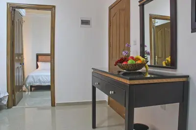 a room with a table with a bowl of fruit on it at Golden Rose Hotel in Aqaba
