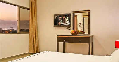 a bedroom with a bed and a desk and a mirror at Golden Rose Hotel in Aqaba