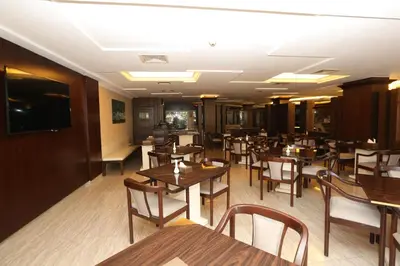 a dining room with wooden tables and chairs at Al Zaitouna Hotel in Aqaba