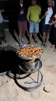 a tray of food on a grill on the beach at North moon Camp in Wadi Rum
