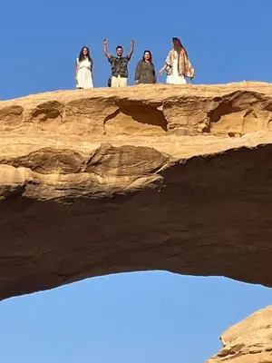 a group of people standing on top of a rock at North moon Camp in Wadi Rum