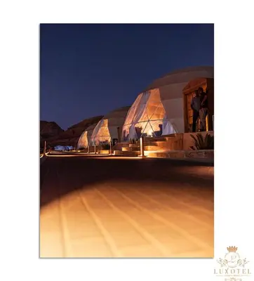 a domed building with people standing outside at night at Wadi Rum UFO Luxotel in Wadi Rum