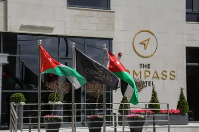 two flags in front of a building at The Compass Hotel in Amman