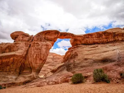 an arch in ayers rock in the desert at Wadi Rum Bright Moon in Wadi Rum