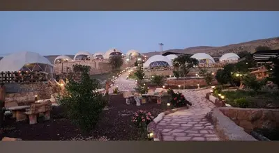 a garden with a stone walkway and buildings with lights at Seven Wonders Luxury Camp in Wadi Musa
