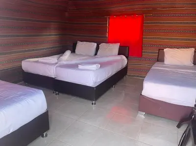 a room with two beds and a red light at Wadi rum Silk Road camp in Wadi Rum