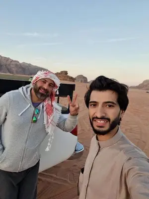 two men are standing in the desert at Qais Camp Wadi Rum in Wadi Rum