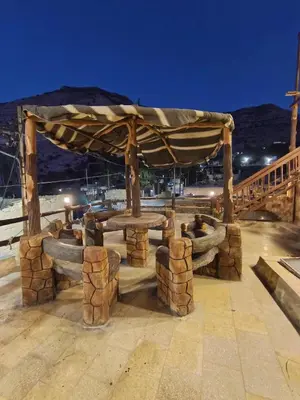a wooden pavilion with a table in the middle at Dana Gate Lodge in Dana