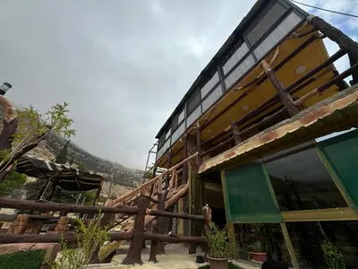 a large building with a wooden railing next to a mountain at Dana Gate Lodge in Dana