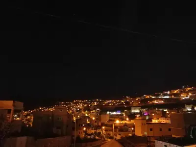 a view of a city at night with lights at Petra Heritage House in Wadi Musa