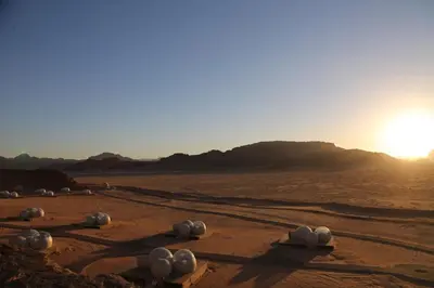 a desert with a group of objects in the sand at Wadi Rum Bubble Luxotel in Wadi Rum