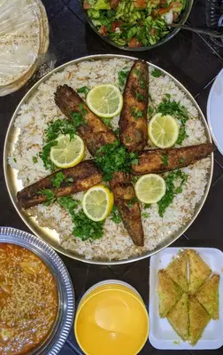 a plate of food with fish and rice and lemon slices at Sunrise camp in Wadi Rum