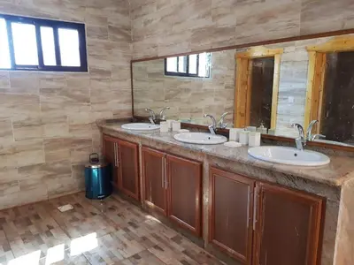 a bathroom with three sinks and a large mirror at Wadi Rum Pyramids Camp in Wadi Rum