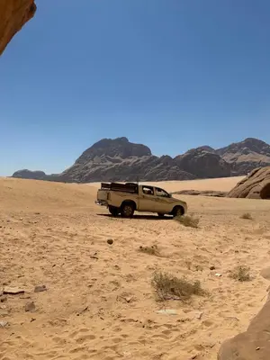 a truck parked in the sand in the desert at Landscape Rum Camp in Wadi Rum