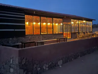 a building with lights on the side of it at Omar Ghazi Camp in Wadi Rum