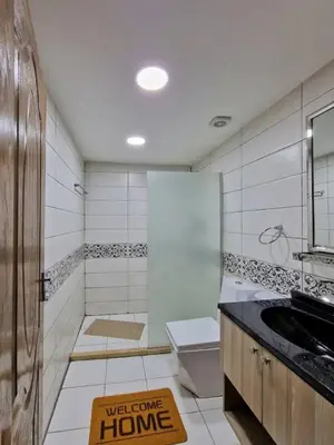 a bathroom with a toilet and a welcome home sign on the floor at Omar Ghazi Camp in Wadi Rum