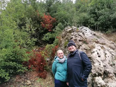 a man and a woman standing next to a rock at Mhna guest house بيت الضيافة الريفي in Ajloun