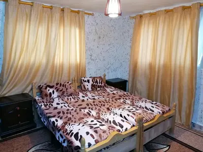 a bedroom with a brown and white bed with curtains at Mhna guest house بيت الضيافة الريفي in Ajloun