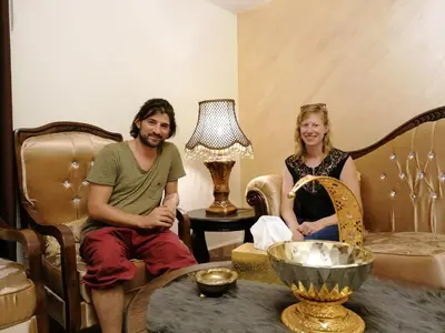 a man and a woman sitting in a living room at Mhna guest house بيت الضيافة الريفي in Ajloun