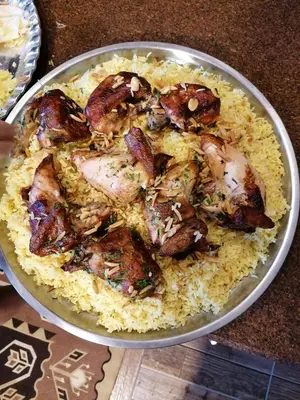 a plate of food with chicken and rice at Mhna guest house بيت الضيافة الريفي in Ajloun
