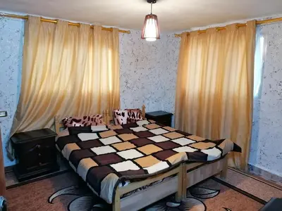 a bedroom with a bed with a checkered blanket at Mhna guest house بيت الضيافة الريفي in Ajloun