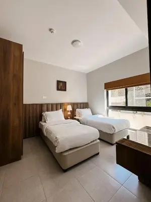 a bedroom with two beds and a window at Celino Hotel in Amman