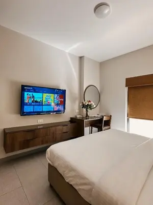 a bedroom with a bed and a flat screen tv at Celino Hotel in Amman