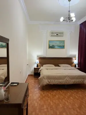 a bedroom with two beds and a mirror at Sufara Hotel Suites in Amman