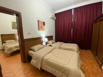 a hotel room with two beds and a mirror at Sufara Hotel Suites in Amman