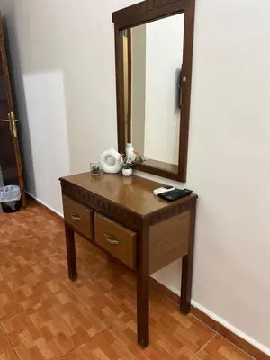a wooden dresser with a mirror on top of it at Sufara Hotel Suites in Amman