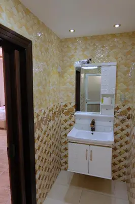 a bathroom with a white sink and a mirror at Petra Guests Hotel in Wadi Musa