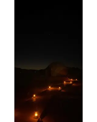 a group of cars with lights in the dark at Rum Jordan camp and tours in Wadi Rum