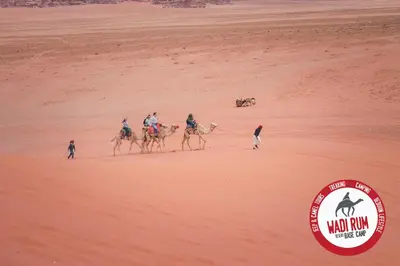 a group of people riding camels in the desert at Wadi Rum Desert Base Camp in Wadi Rum