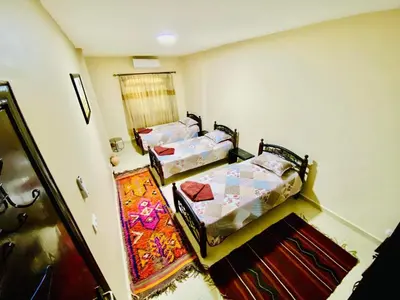 a room with two beds in a room with a window at Petra View Flat in Wadi Musa