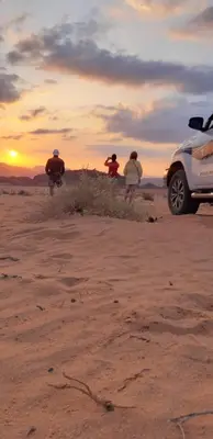 a group of people standing on the beach with surfboards at bedouin future camp in Wadi Rum