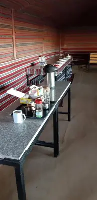 a row of tables in a room with food on them at bedouin future camp in Wadi Rum