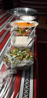 three plastic containers of food on a table at bedouin future camp in Wadi Rum
