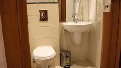 a small bathroom with a toilet and a sink at Big Ben Hotel Suites in Amman