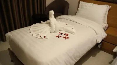 a towel animal sitting on top of a bed at Big Ben Hotel Suites in Amman
