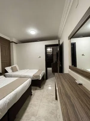 a hotel room with two beds and a table at mass paradise2 in Aqaba