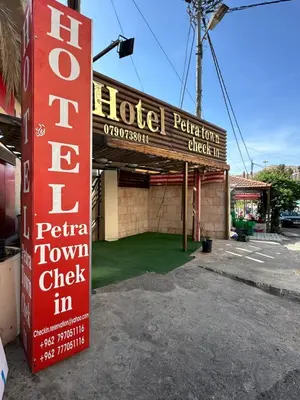 a hotel with a sign in front of a building at Petra Town Check-Inn in Wadi Musa