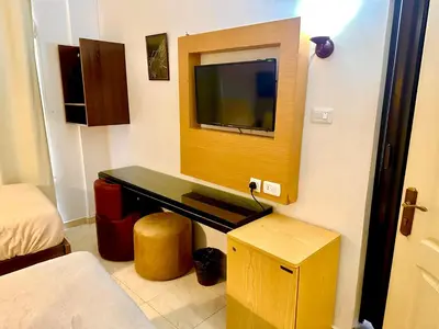 a room with a tv on a wall with a bed at Petra Town Check-Inn in Wadi Musa