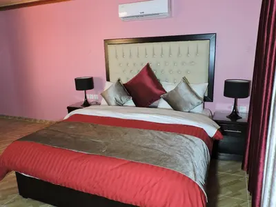 a bedroom with a large bed with red and grey pillows at Valentine Inn Luxury in Wadi Musa